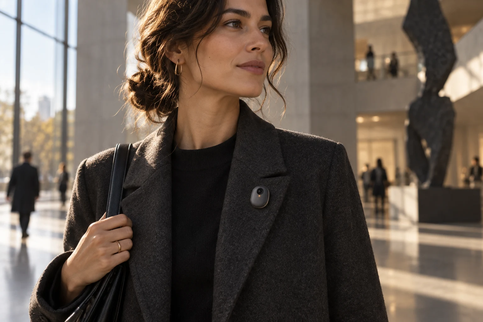 A woman wearing the proposed AVA pin on her coat in a sunlit museum